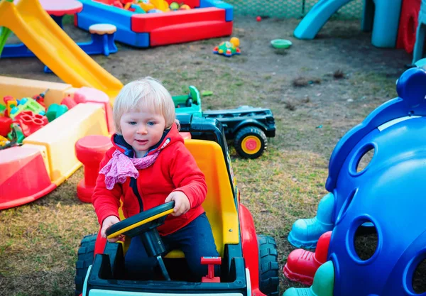 Menina jogar com brinquedo carro no playground — Fotografia de Stock