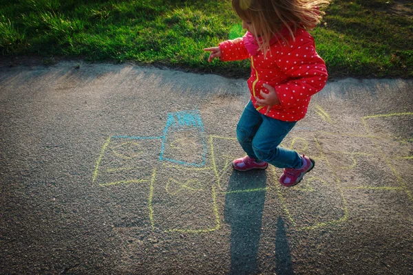 Menina jogar hopscotch no playground — Fotografia de Stock