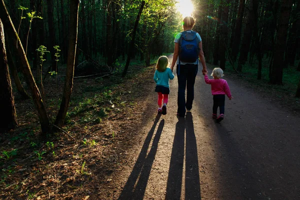 Madre awith niños caminando en la naturaleza puesta del sol — Foto de Stock