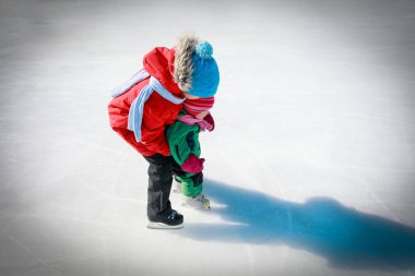 Büyük oğlan küçük kız kardeşine kaymayı öğretiyor, çocuklara kış sporu.