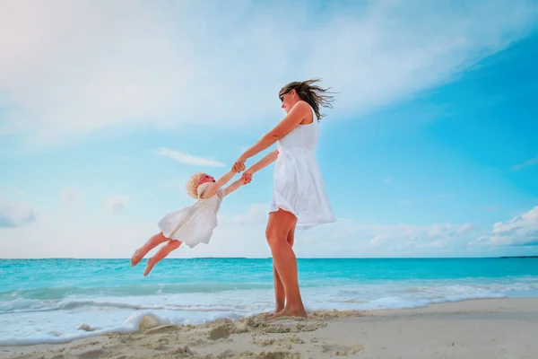 Moeder en gelukkig dochtertje spelen op strand — Stockfoto