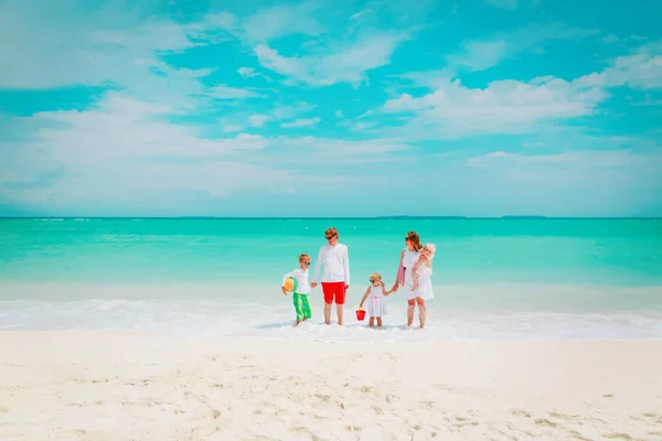 Üç çocuklu mutlu bir aile sahilde yürüyor. — Stok fotoğraf