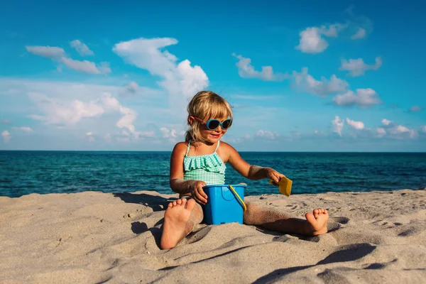 Linda niña jugar con arena en la playa — Foto de Stock