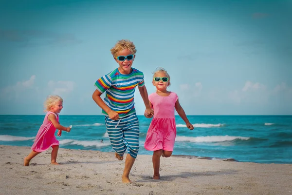 Šťastné děti - malý chlapec a dívky - běhat a hrát si na pláži — Stock fotografie