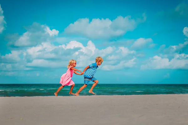 Ragazza felice e ragazzo correre sulla spiaggia, i bambini godono di vacanza al mare — Foto Stock