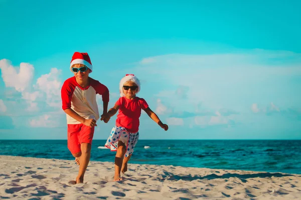 Szczęśliwy kids mały chłopiec i dziewczynka - obchodzi Boże Narodzenie na plaży — Zdjęcie stockowe