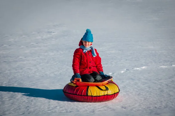 Feliz lindo chico disfrutar de diapositivas de invierno, juego de niños en la naturaleza — Foto de Stock