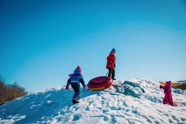 Crianças felizes- menino e meninas- brincar com a neve na natureza inverno, família no slide — Fotografia de Stock