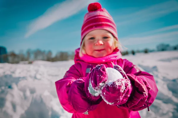 Μικρό κορίτσι κάνει χιονόμπαλα στη φύση του χειμώνα — Φωτογραφία Αρχείου