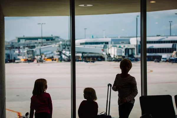 Niños- niño y niñas- con el equipaje esperando avión en el aeropuerto — Foto de Stock