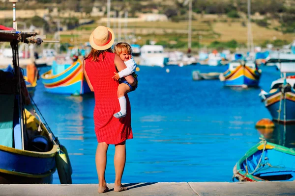 Мать и милая маленькая дочь, глядя на традиционные лодки на Мальте — стоковое фото