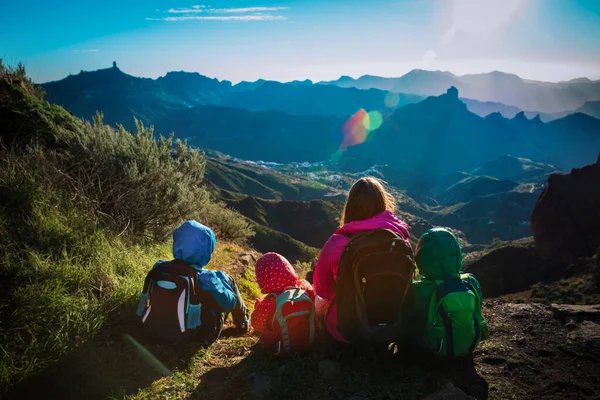 子供を持つ母親は夕日の山を旅し家族は風光明媚な自然を見て — ストック写真