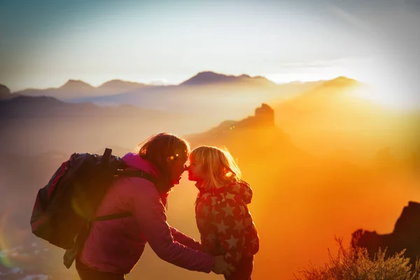 Mãe e filha viajam nas montanhas do pôr do sol, silhueta familiar — Fotografia de Stock