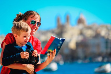 Anne ve oğlu Malta, Avrupa 'ya seyahat ediyor, aile seyahat rehberine bakıyor.