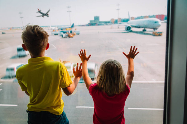 kids- boy and girl-waiting for plane in airport
