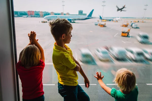 Kölykök - fiú és lányok - repülőre várnak a reptéren — Stock Fotó