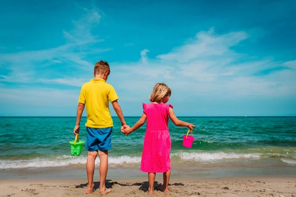 Дети, мальчик и девочка играют с песком на пляже. — стоковое фото