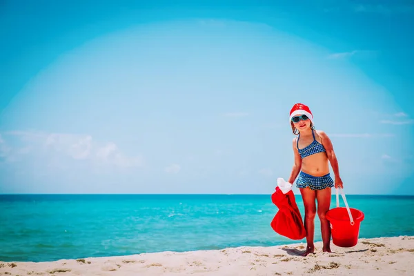Noel 'i tropikal plajda kutlayan tatlı küçük kız. — Stok fotoğraf