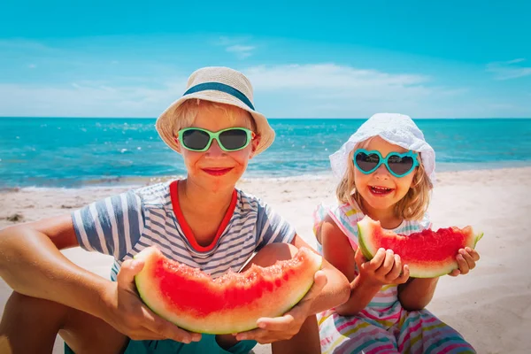 Felice ragazzo carino e ragazza mangiare anguria in spiaggia — Foto Stock