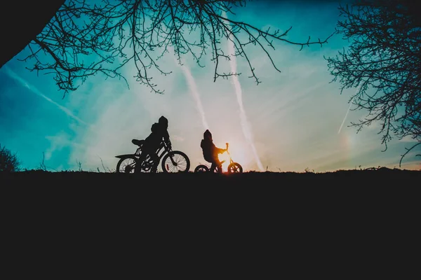 Маленький хлопчик і дівчинка катаються на велосипедах у природі заходу сонця — стокове фото