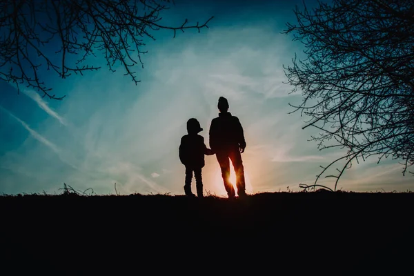 Far och son gå i solnedgången natur, föräldraskap — Stockfoto
