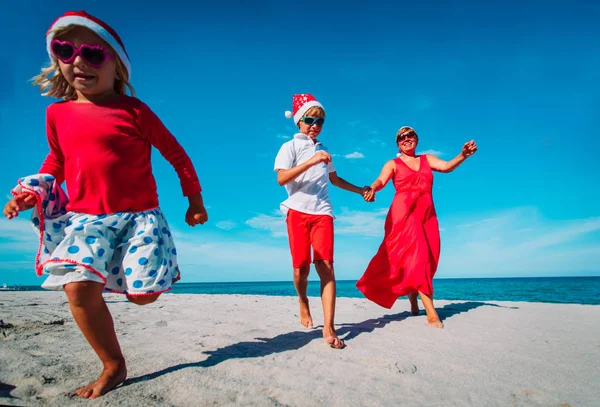 Happy family -mother with kids- run and have fun on Christmas beach — Stock Photo, Image