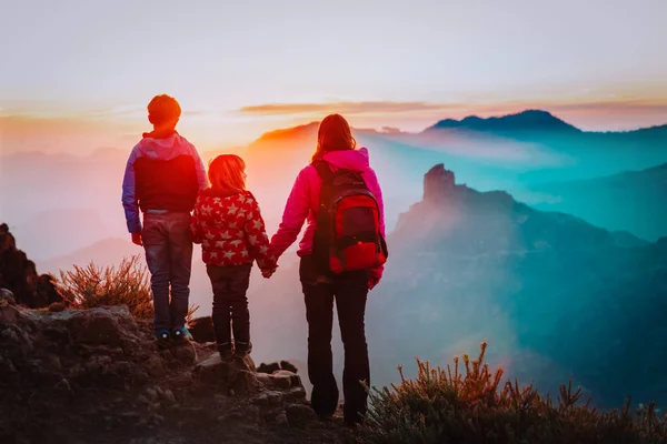 Мать с сыном и дочерью путешествуют в горах заката — стоковое фото