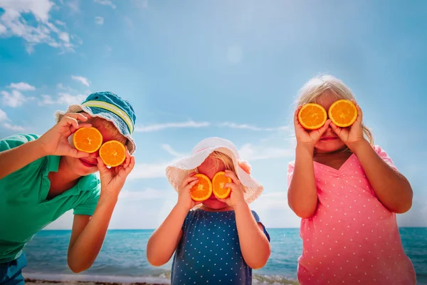 Heureux garçon et les filles profiter de la plage, montrant les yeux orange — Photo