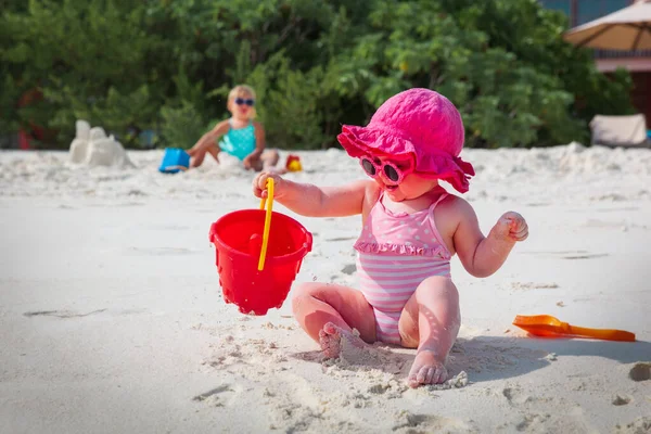 Roztomilé holčičky hrát s pískem a hračky na pláži — Stock fotografie