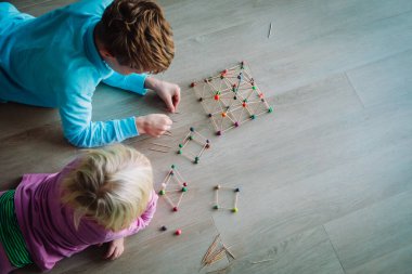 Erkek ve kız geometrik şekiller, mühendislik ve kök eğitimi yapıyorlar.