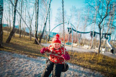 Sahada salıncakta sallanan sevimli küçük kız.