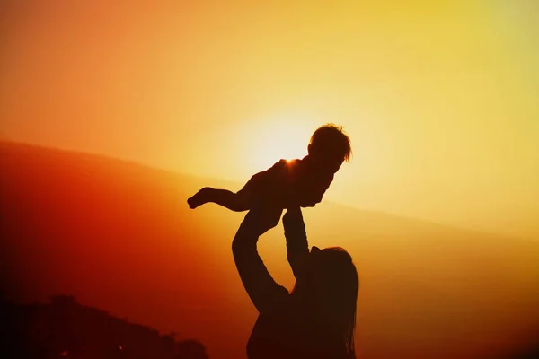 Moeder en dochtertje spelen bij zonsondergang natuur — Stockfoto