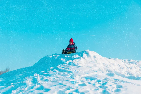 Kinder-Winterspaß - kleines Mädchen rutscht im Schnee — Stockfoto