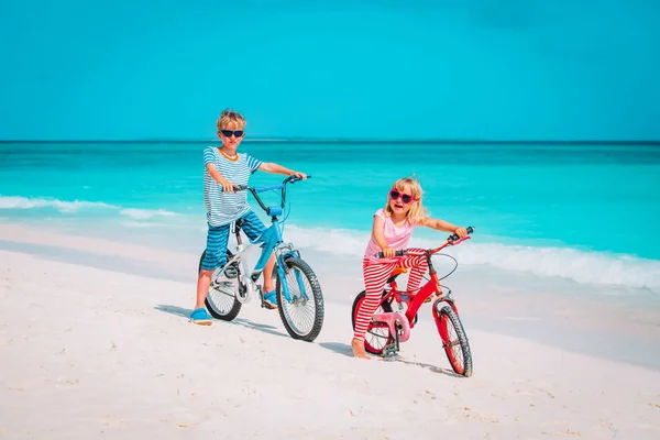 Bambino e ragazza andare in bicicletta sulla spiaggia — Foto Stock