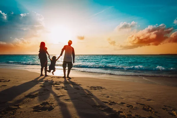 Família feliz com crianças em jogo na praia do por do sol — Fotografia de Stock