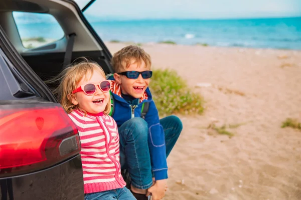 Happy little boy and girl enjoy travel by car at beach — Stock Photo, Image