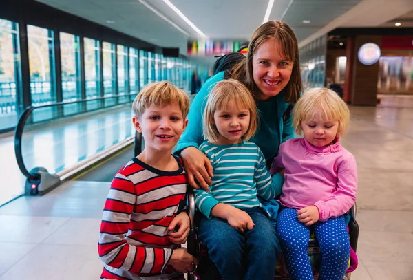 Madre con tres hijos viajan en el aeropuerto, viajes en familia —  Fotos de Stock
