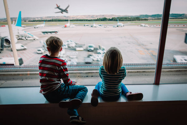 kids- boy and girl-waiting for plane in airport
