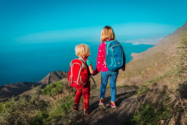 Little girls hiking in mountains near sea — ストック写真