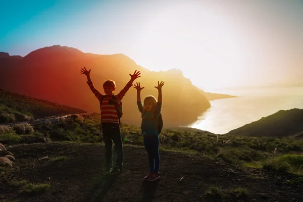 Menino feliz e menina viajar nas montanhas ao pôr do sol, as crianças gostam de caminhadas — Fotografia de Stock