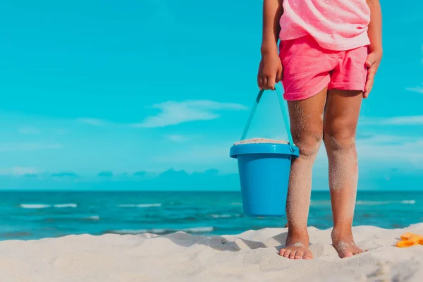 Menina jogar com areia em férias na praia — Fotografia de Stock