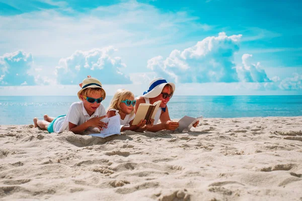 Matka z synem i córką czytają książki na plaży — Zdjęcie stockowe