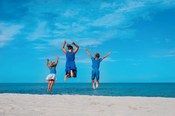 Família desfrutar de praia, mãe com crianças saltar em férias no mar — Fotografia de Stock