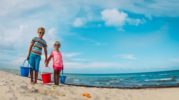 Menino bonito feliz e menina jogar com areia na praia — Fotografia de Stock