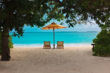 Tropikal deniz tatilinde iki plaj sandalyesi