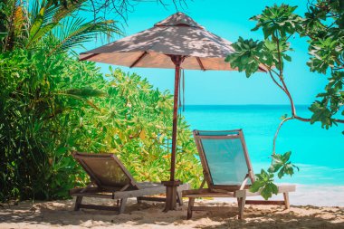 Tropikal deniz tatilinde iki plaj sandalyesi