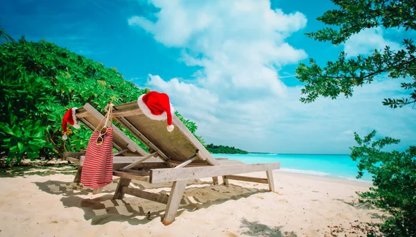 Navidad en la playa-silla salones con sombreros de Santa en el mar —  Fotos de Stock