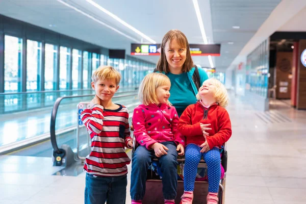 Madre con tres hijos viajan en el aeropuerto, vacaciones en familia — Foto de Stock