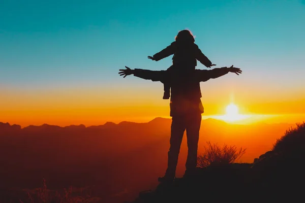 Счастливые отец и дочь путешествуют в горах на закате — стоковое фото