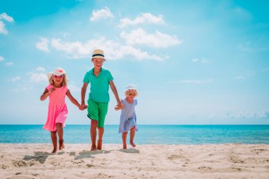 Mutlu çocuk ve kız plaj tatilinde koşuyorlar